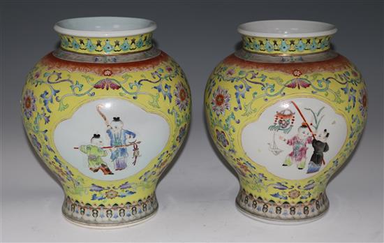 A pair of Chinese yellow ground famille rose vases, 29cms